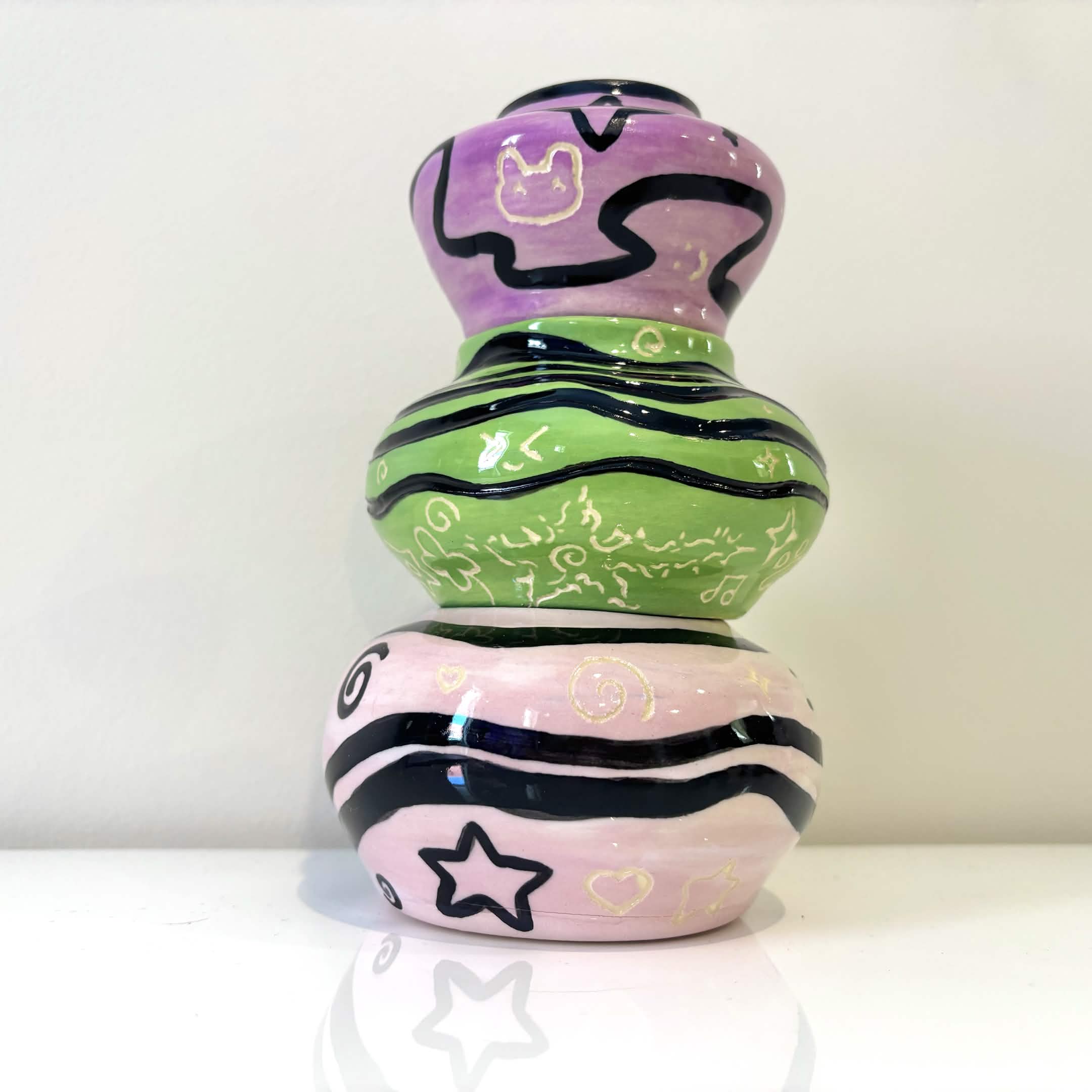 Stack of handmade ceramic pieces with stars and illustrated details